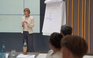 Systemischer Coach Andrea Bertagnolli-Windstoßer erklärt am Flipchart.